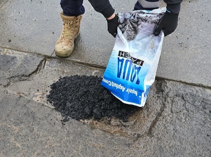 Aqua Patch 20 kg bag beside the repair material at a pothole